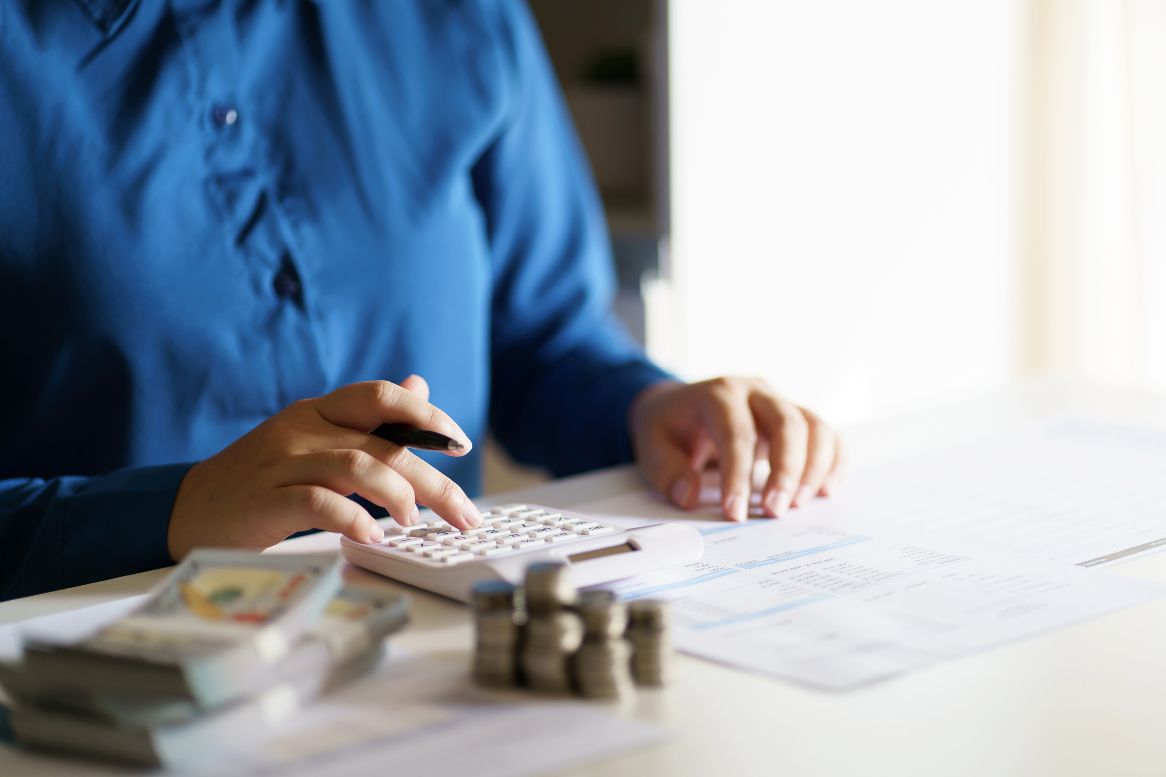 Business woman calculating financial statement on calculator income tax online return and payment.